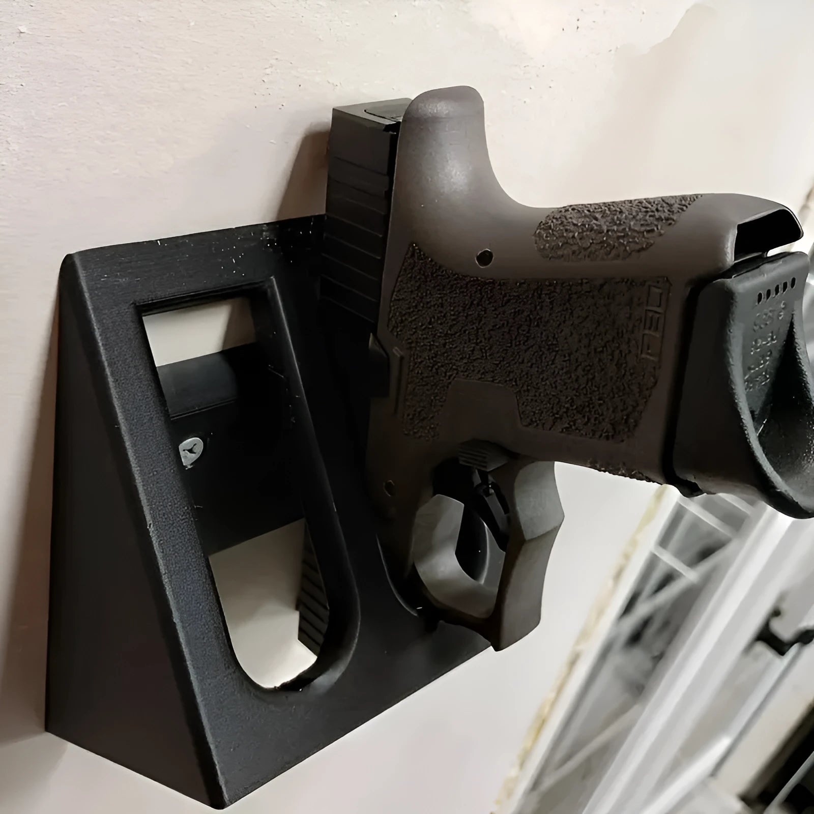 Black punk-style plastic pistol display stand on a flat surface.