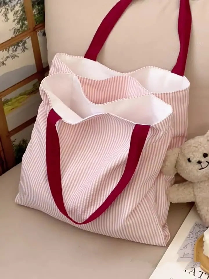 Casual multi-layer canvas tote shoulder bag in a plaid pattern with a wide strap.