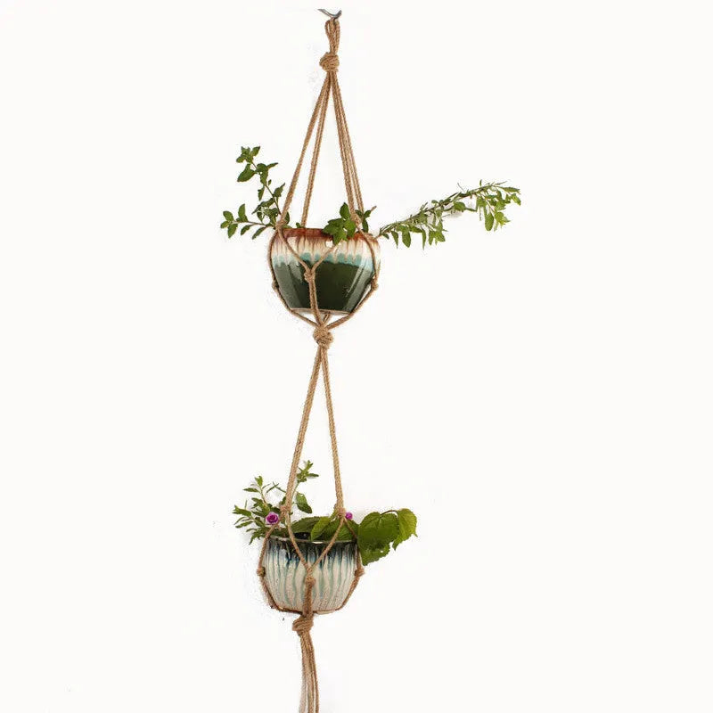 A rustic woven wire plant basket made from cotton rope, holding a green potted plant.