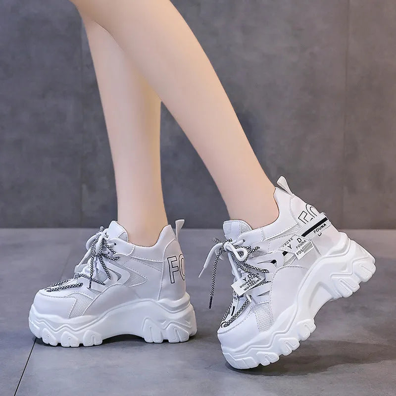 Women's white and black mesh platform sports shoes with cross strap and rubber sole.