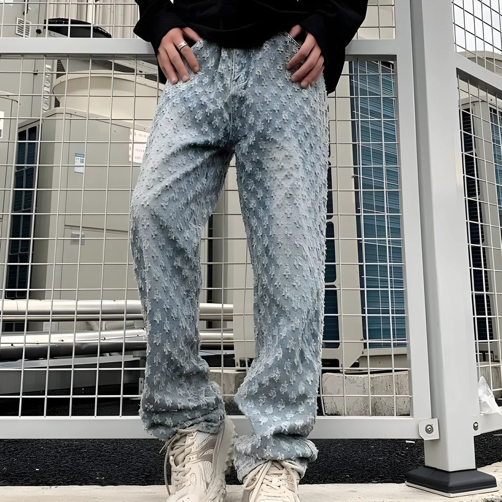 Men's black jacquard full-print denim jeans with button fly, laid flat showing all-over pattern