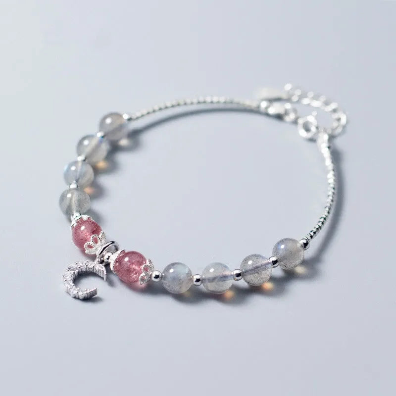 Handmade adjustable moonstone bracelet with crescent moon charm and crystal pendant on wrist