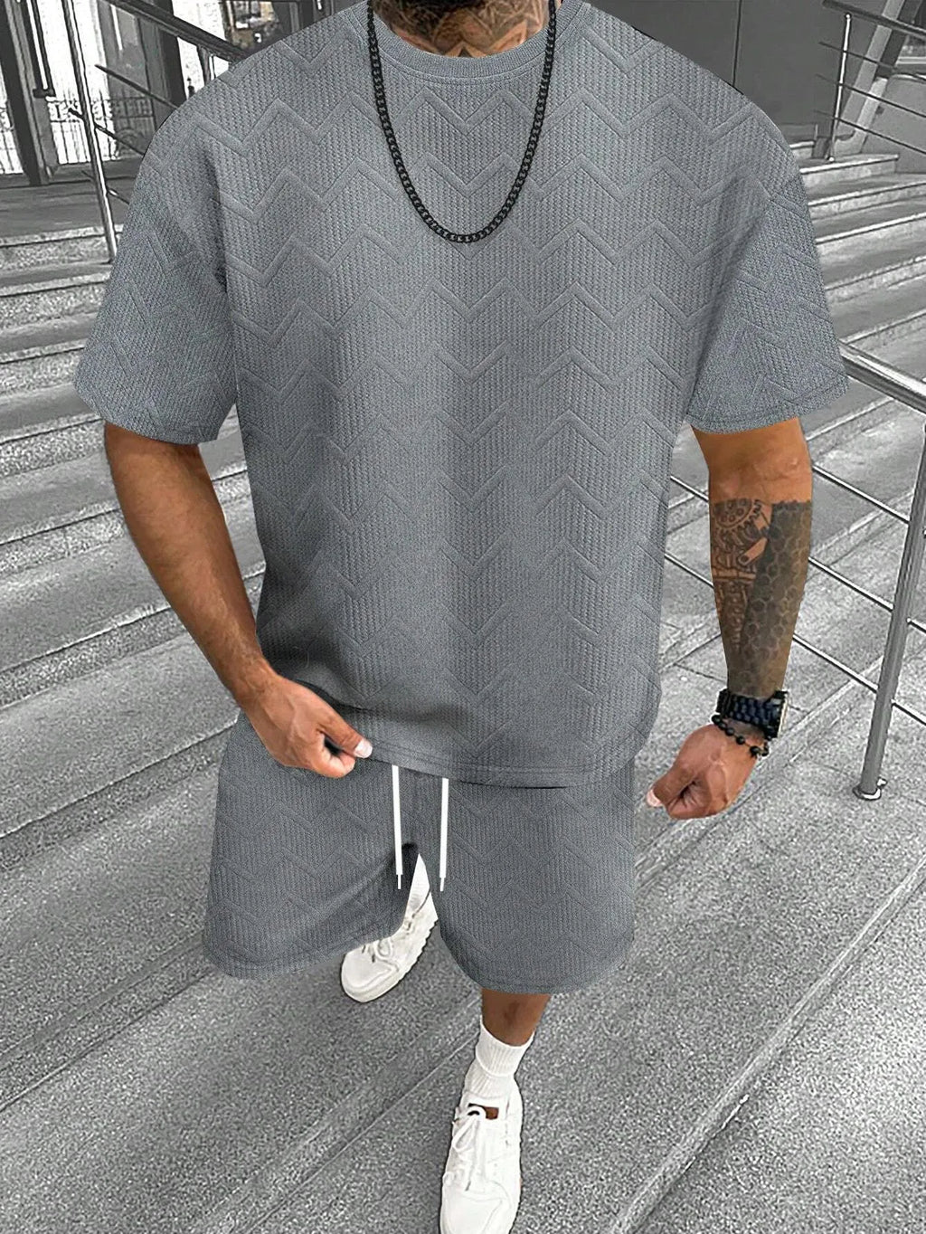 Men's blue short sleeve shorts leisure suit on a hanger, showing the top and pants.