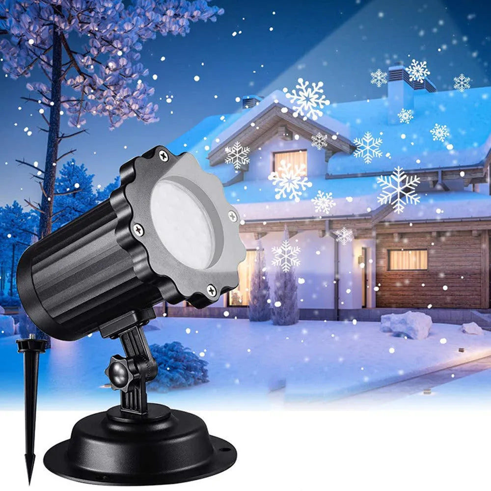 LED Christmas snowflake laser light projector IP65 waterproof with white snowflakes projecting onto a garden wall at night