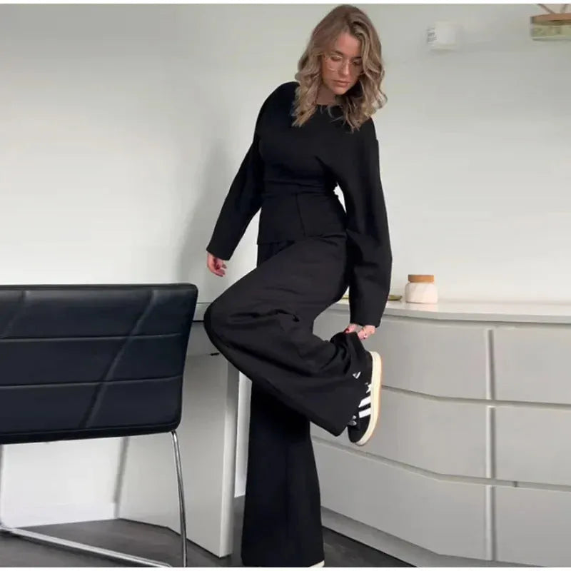 Women's black polar fleece suit with O-neck long sleeve top and wide-leg trousers on a hanger