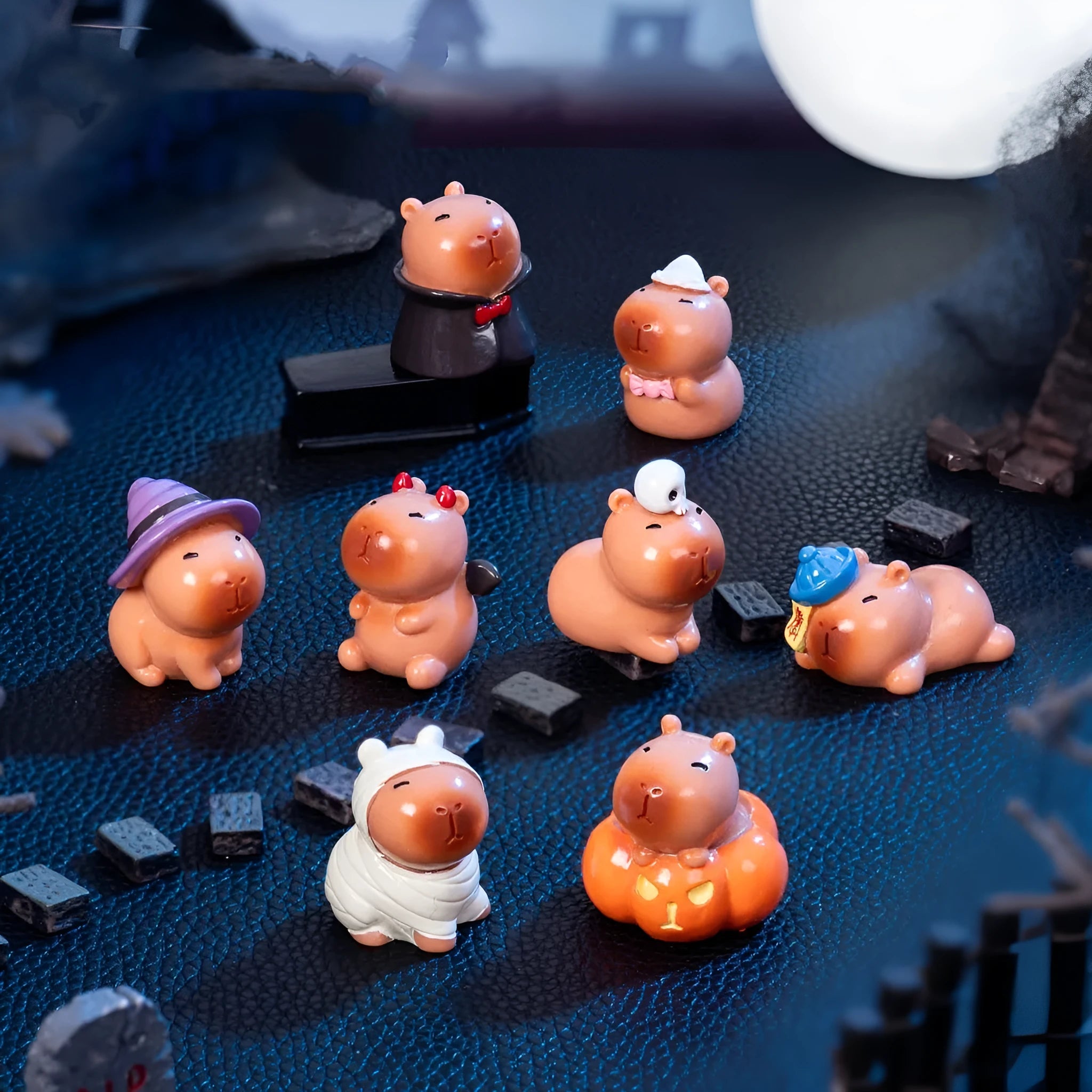Eight different Halloween-themed capybara resin figurines displayed together