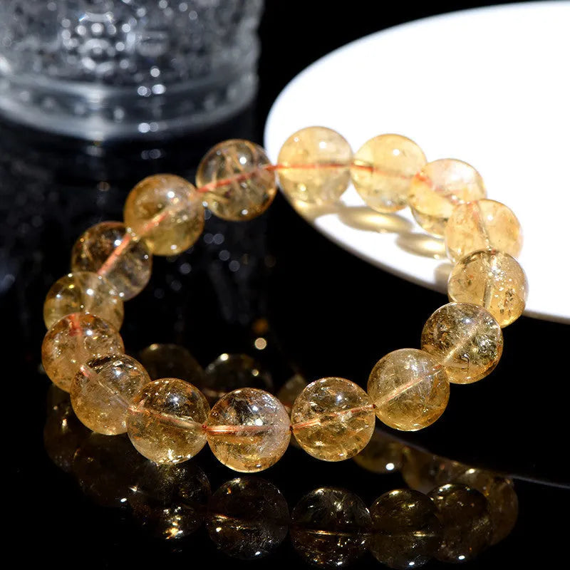 Natural yellow citrine gemstone bracelet with geometric beads on white background