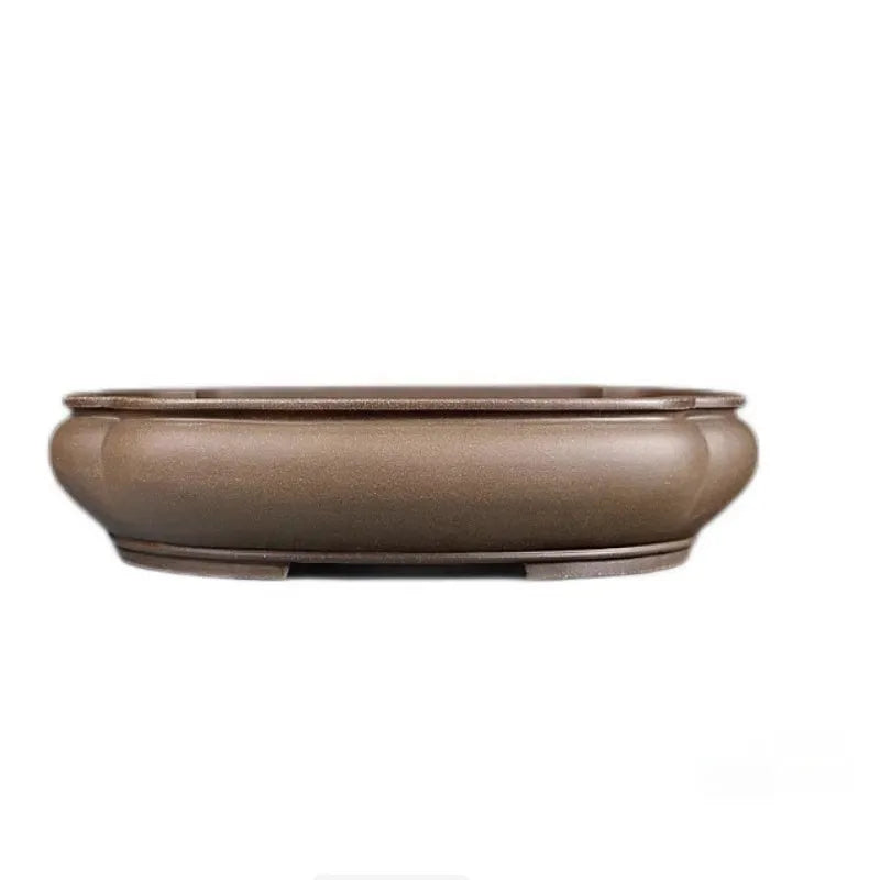 Handmade antique papaya-shaped purple clay flower pot on a tabletop.