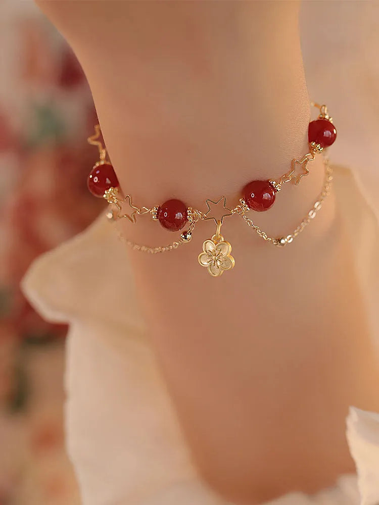 Red agate double layer bracelet with floral and peach blossom design on a wrist