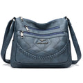 Soft PU leather women's shoulder bag in black colour showing crossbody strap and exterior pockets