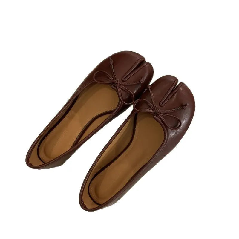 Women's black split-toe flat pumps with a round toe and slip-on oversleeve design.