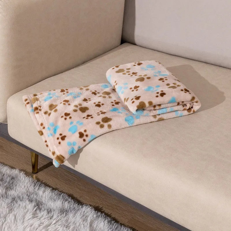 Blue cartoon dog pattern double-sided flannel pet blanket shown on a dog bed.