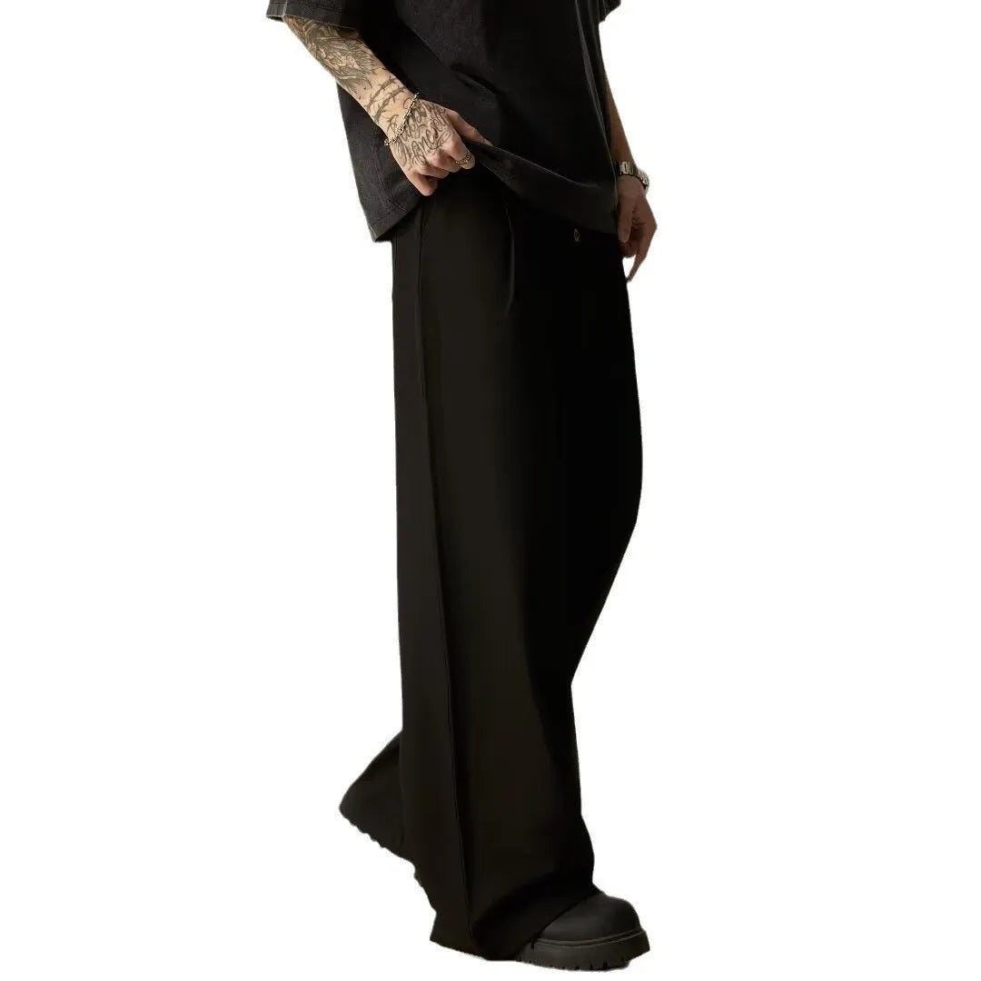Men's black casual trousers with wide-leg design and button fly closure showing elastic waistband detail