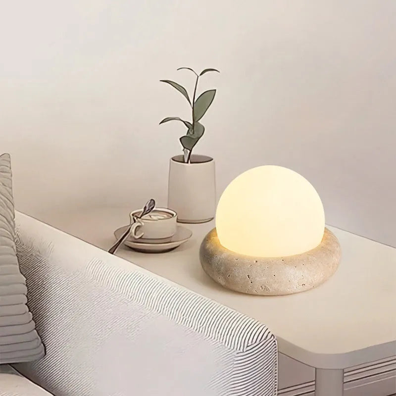 Cream coloured bedside night lamp with remote control on wooden table