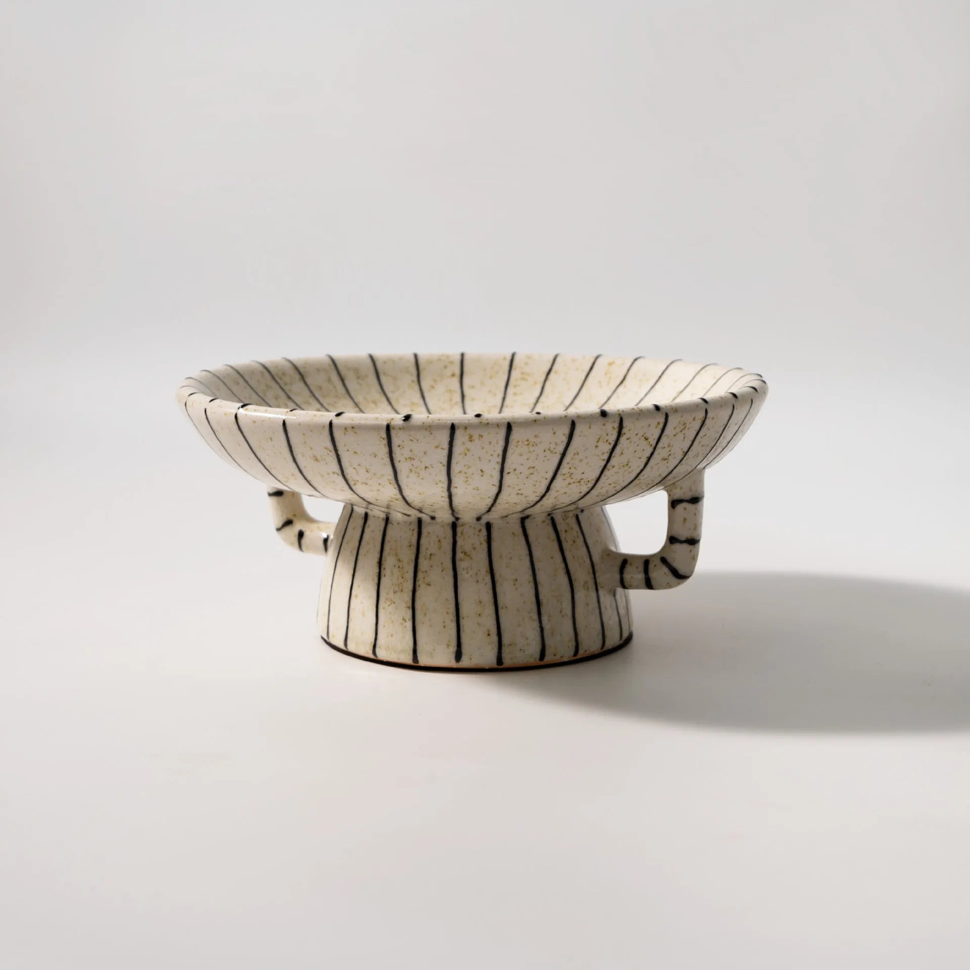 Black and white striped synthetic resin fruit plate on table