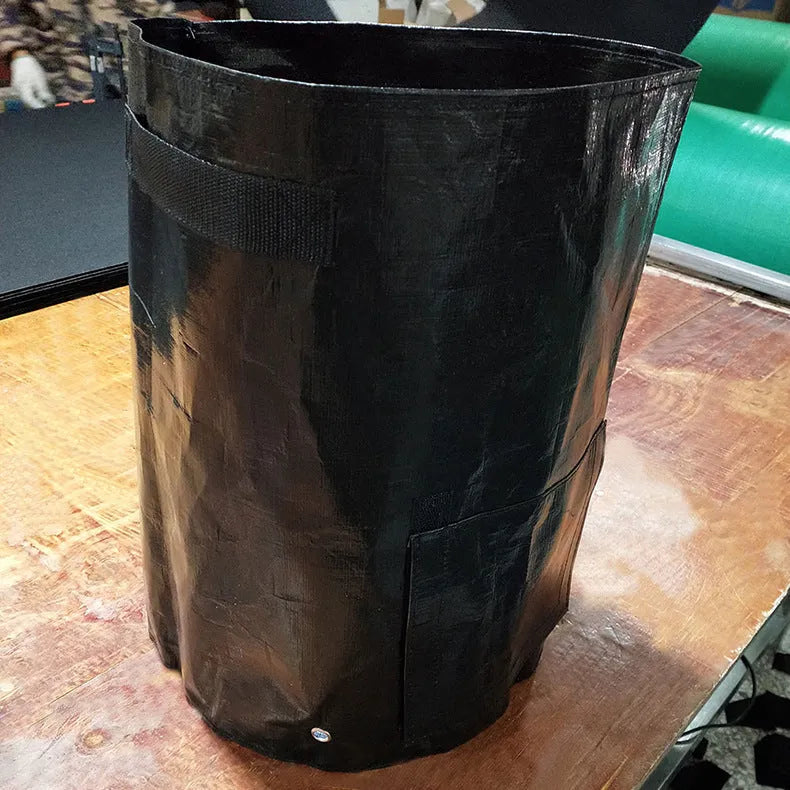 Dark green PE cloth planting bag with side windows and double handles, 34x35cm, for growing potatoes on a balcony.
