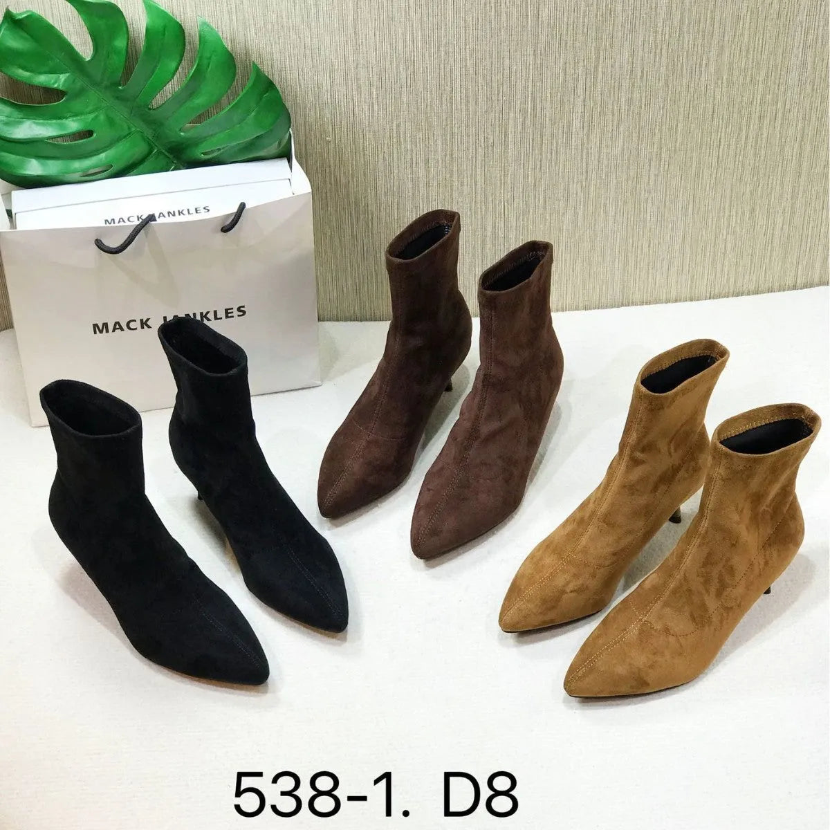 Women's black pointed-toe ankle boots with a stiletto heel and mid-calf sock length.