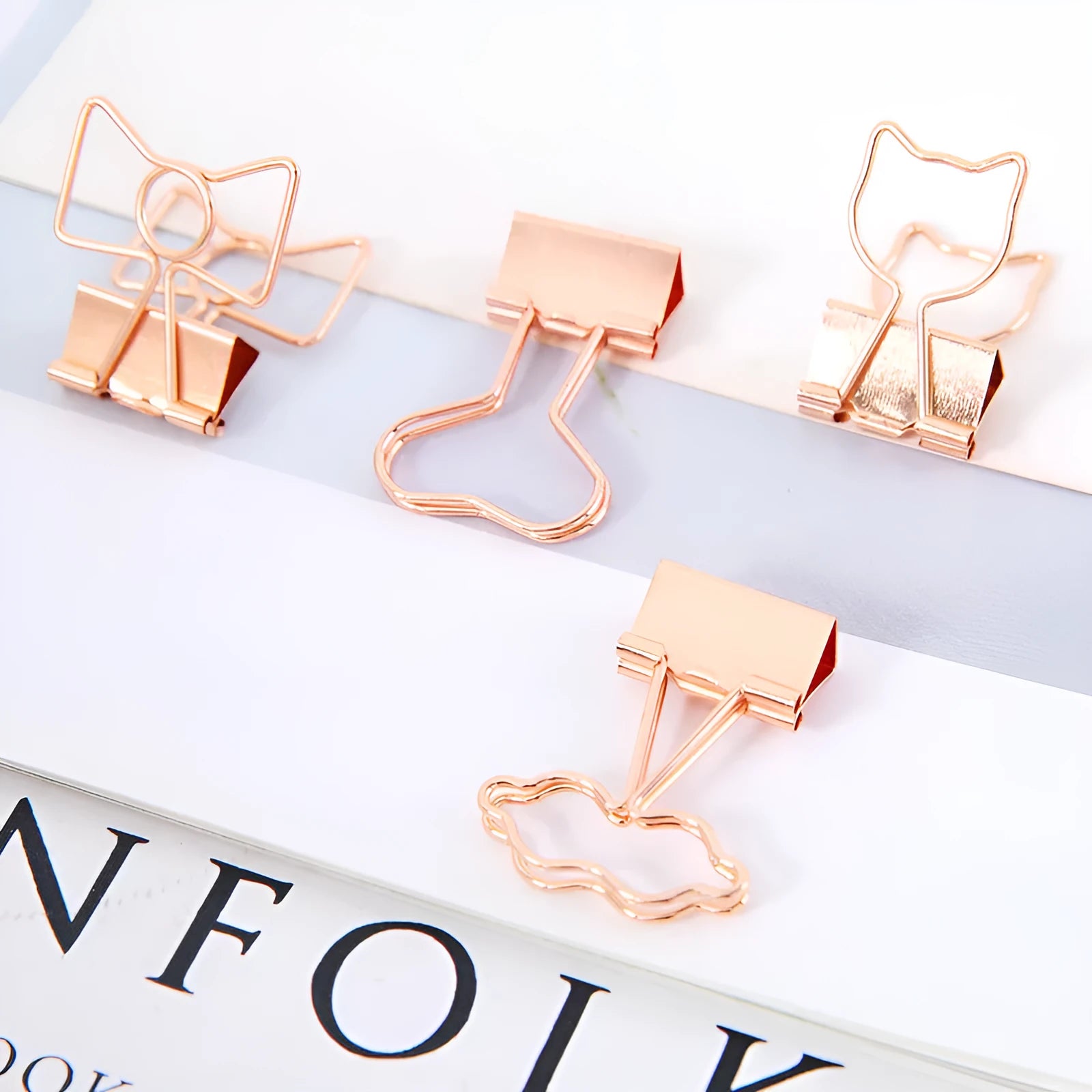 Gold metal decorative paper clip in a bow shape with a long tail design.