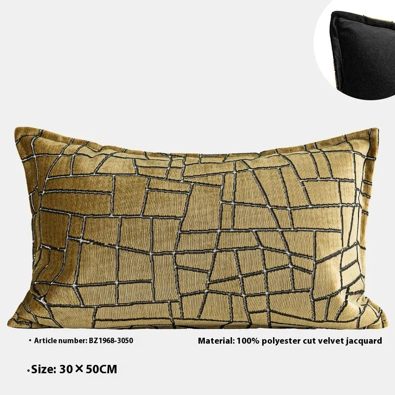 Gold geometric patterned decorative pillow on a grey sofa.