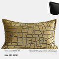 Gold geometric patterned decorative pillow on a grey sofa.
