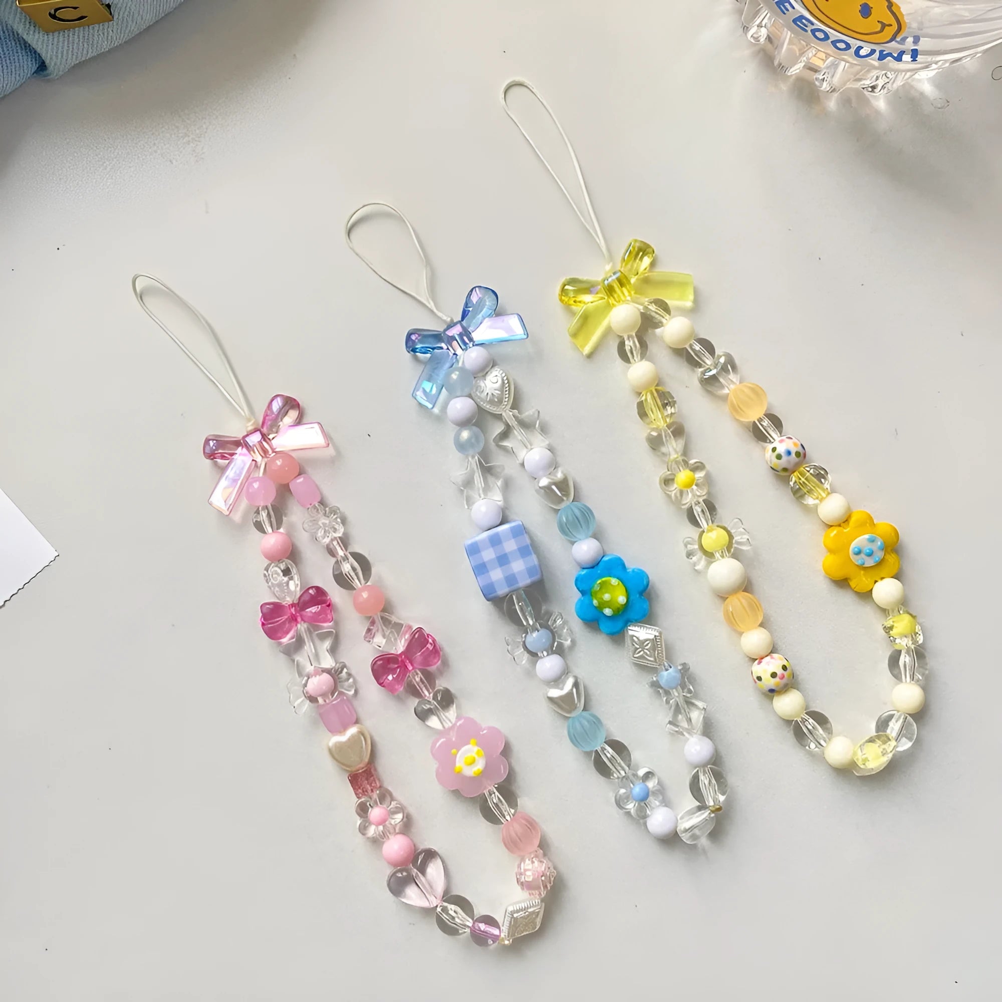 Beaded flower mobile phone lanyard with adjustable sliding bead in blue, pink, and yellow colour options