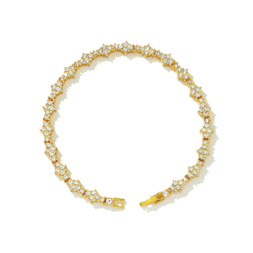 Flower-shaped cross tennis chain bracelet in gold alloy on white background showing diamond and geometric detailing