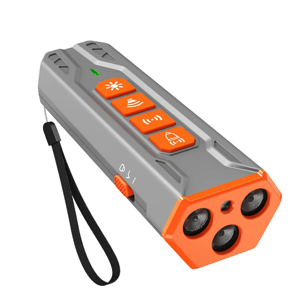 Grey and orange three-head ultrasonic dog trainer with remote control on a table.