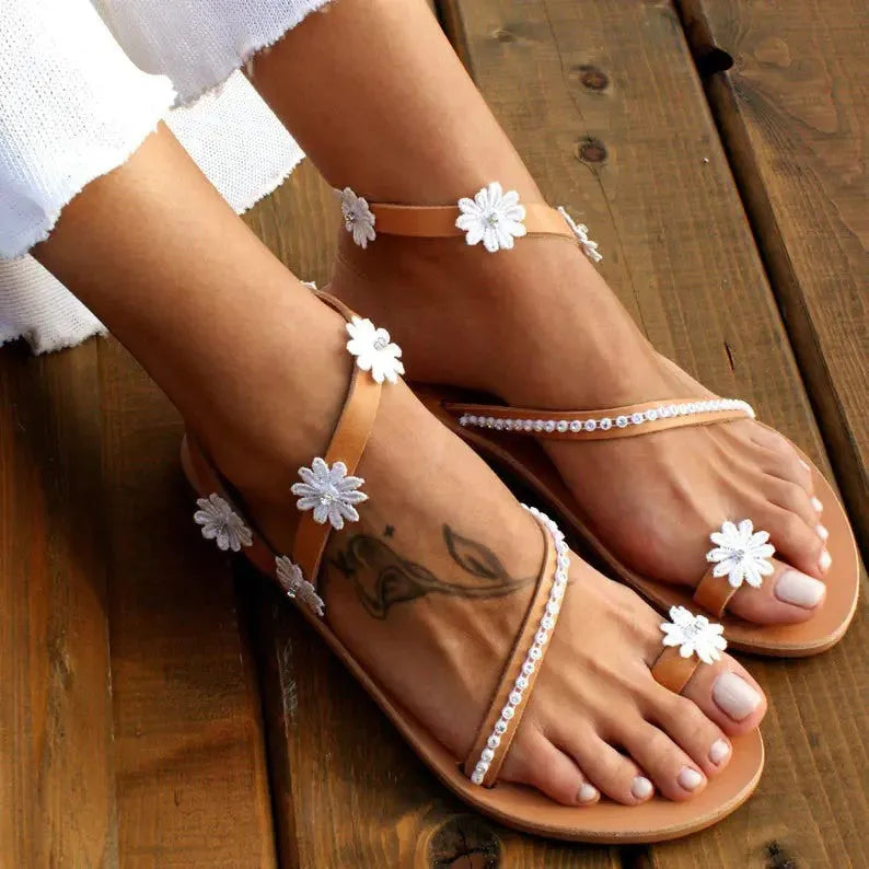 Brown Roman sandals with floral pattern, herringbone toe, and flat rubber sole