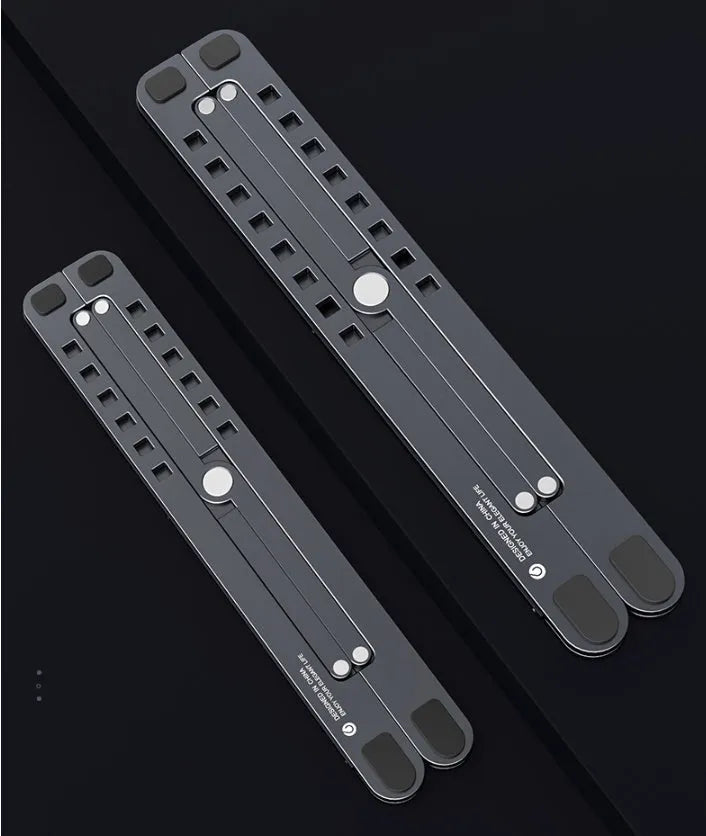 Deep grey foldable aluminium laptop stand holding a silver laptop at an angle.