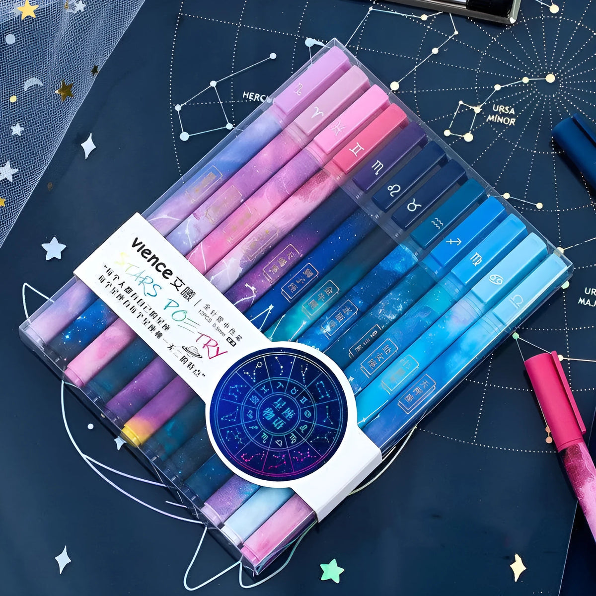 Twelve constellation ballpoint pens with zodiac designs on a light background