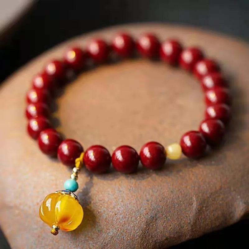 Close-up of a handcrafted wave-pattern bracelet made from red cinnabar and copper beads.