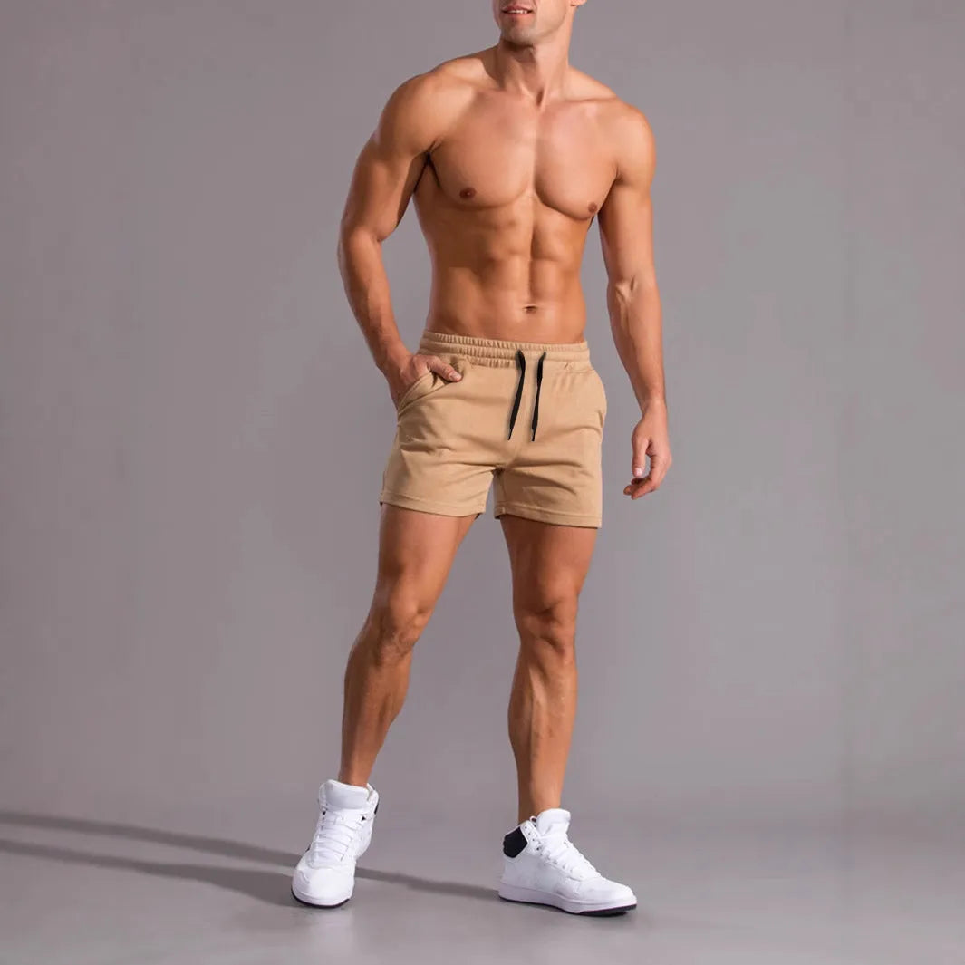 Three pairs of men's solid colour shorts in black, khaki, and light brown with drawstring waistbands