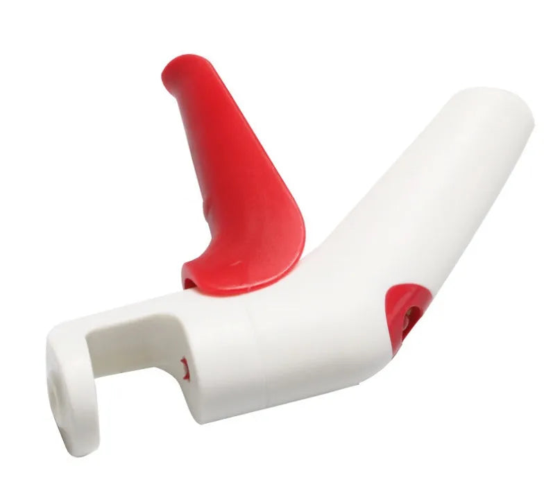 Manual cherry pitter tool with stainless steel coring mechanism on a kitchen worktop.