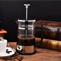 Compact pour-over coffee maker with glass carafe and stainless steel filter holder