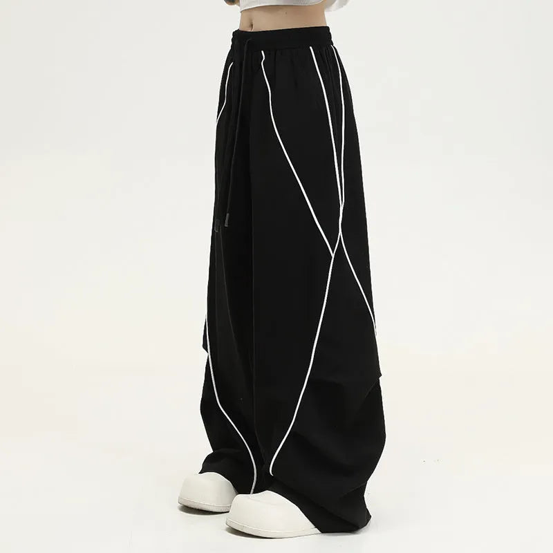 Black and grey striped men's wide-leg pleated sports pants on a hanger.