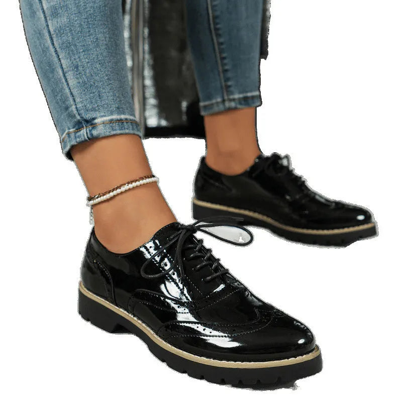 Women's black sequined lace-up loafers with a wedge heel and round toe, shown on a mid-calf.