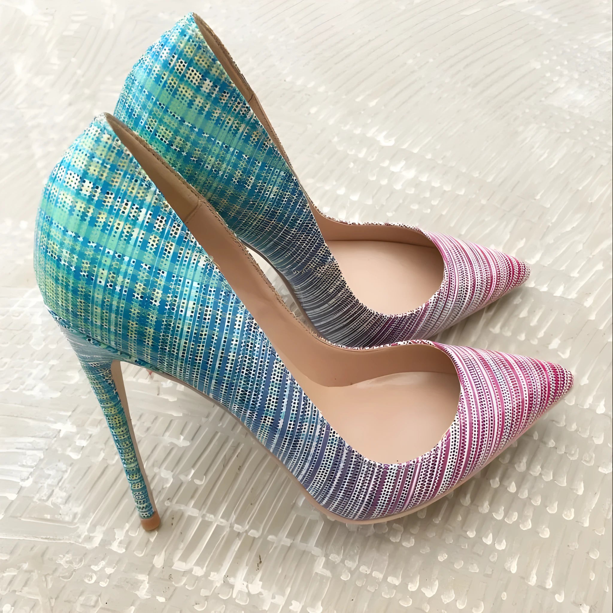 Women's pink and blue gradient patent leather stiletto heels with a pointed toe on a rubber sole.