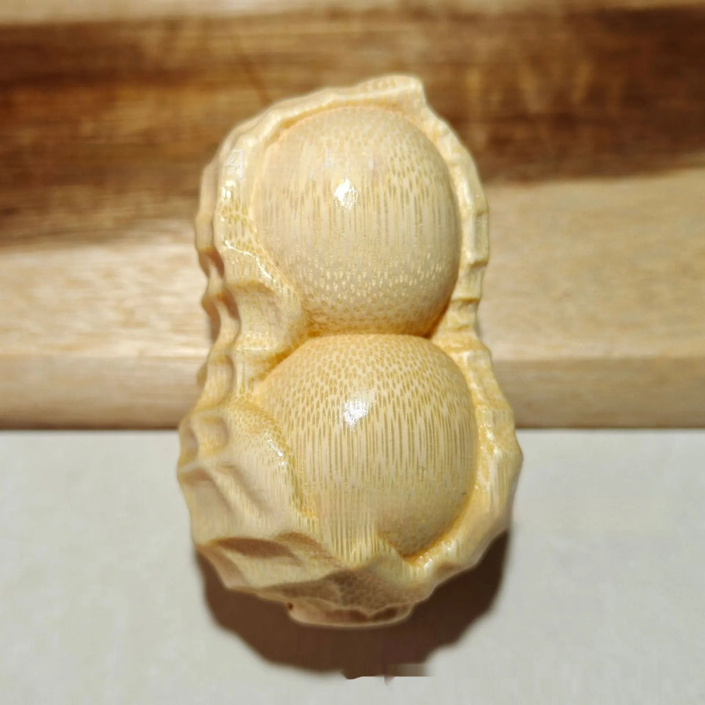 Modern minimalist solid bamboo carving peanut ornament on a neutral background.