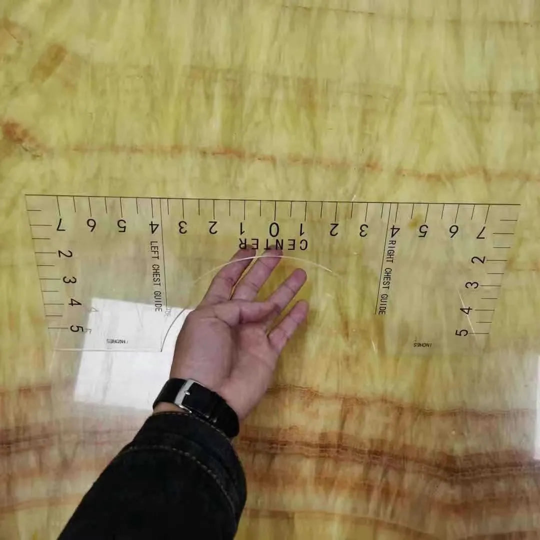Transparent acrylic sewing ruler for aligning T-shirt designs, measuring 10 by 6 inches.
