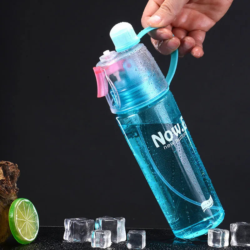 Portable mist spray sports water bottle with transparent body, handle, and press-to-spray mouth