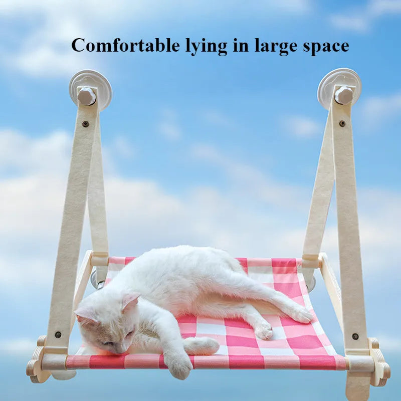 Pink foldable wooden cat window bed with suction cups attached to a glass window