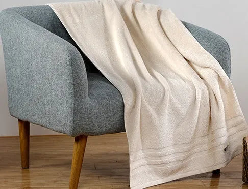 Beige and brown cotton towel set showing three sizes: square face cloth, hand towel, and bath towel.