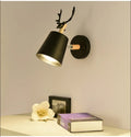Modern antler wall lamp in black finish with iron and wood construction, measuring 24x29cm
