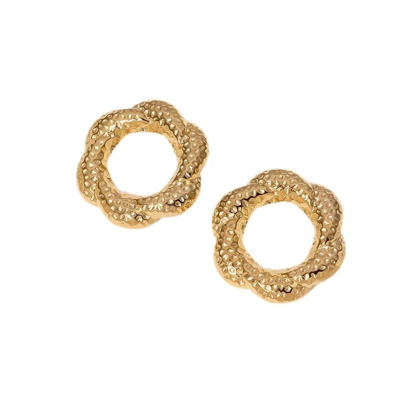 Stainless steel round stud earrings in gold and steel colours on a neutral background