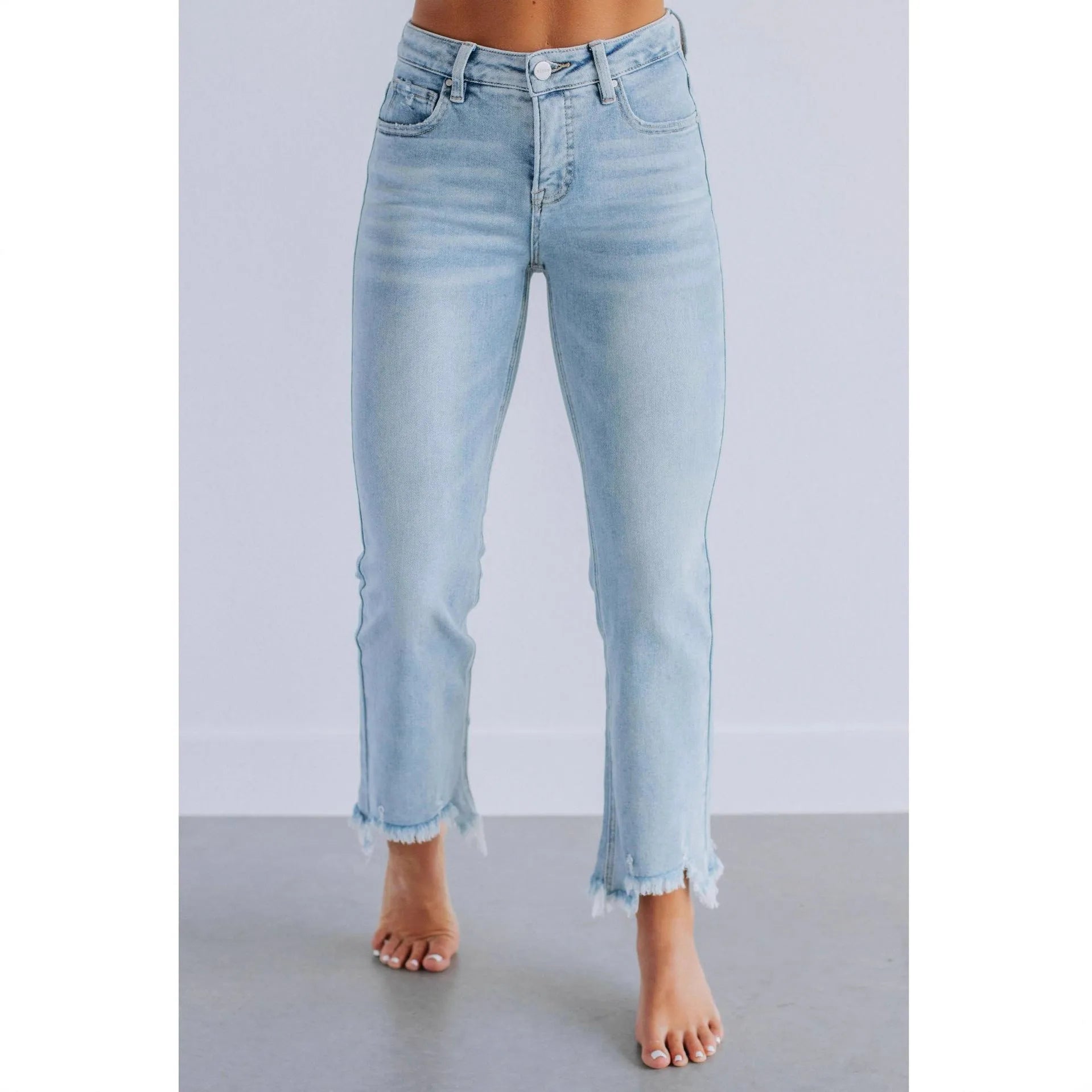 Women's dark blue denim jeans with hand-worn distressing detail on a hanger.