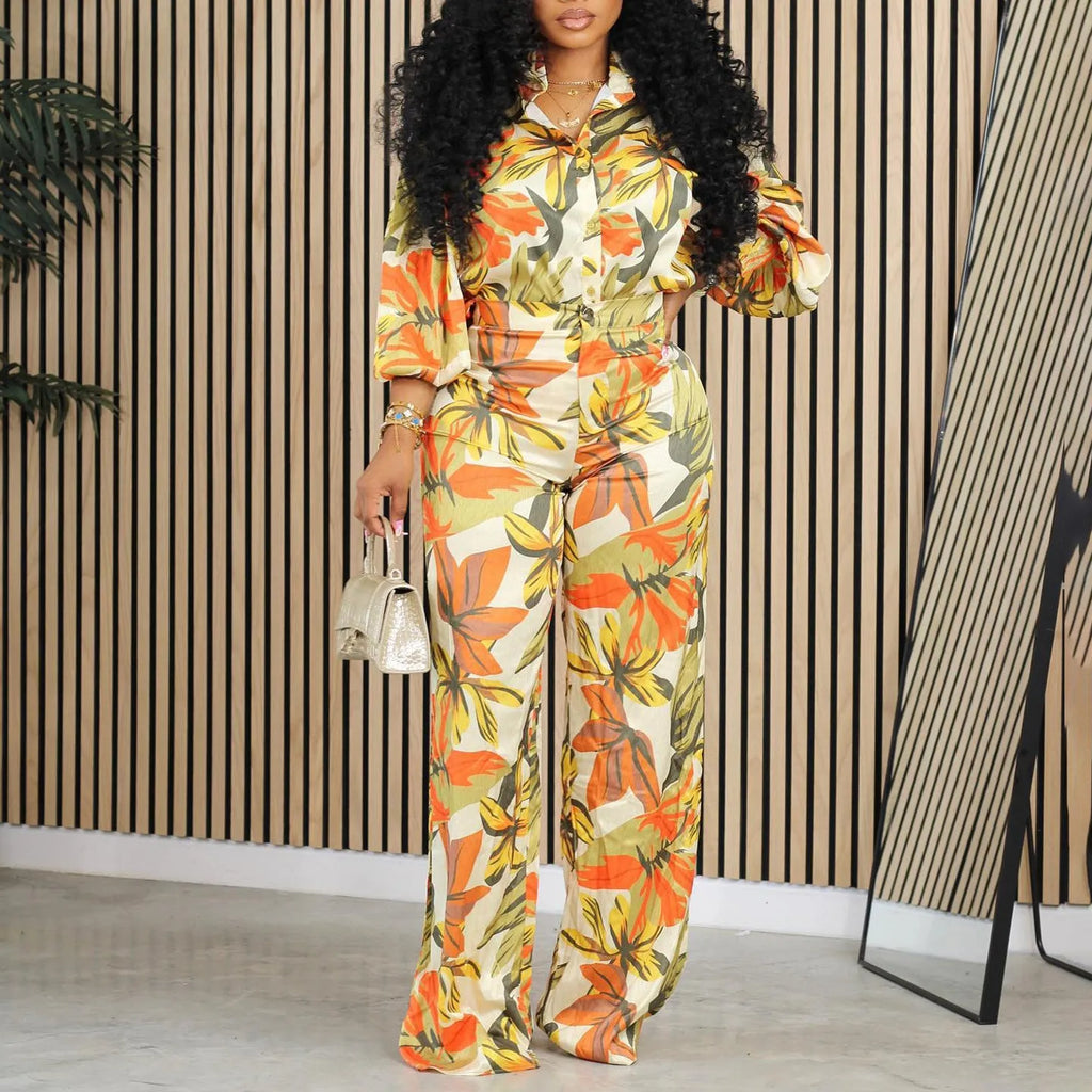 Red women's polyester printed long sleeve shirt and wide leg pants suit set laid flat.