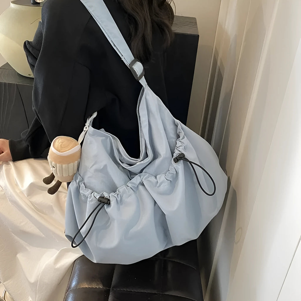Green pleated polyester crossbody bag showing split pocket design and folding construction