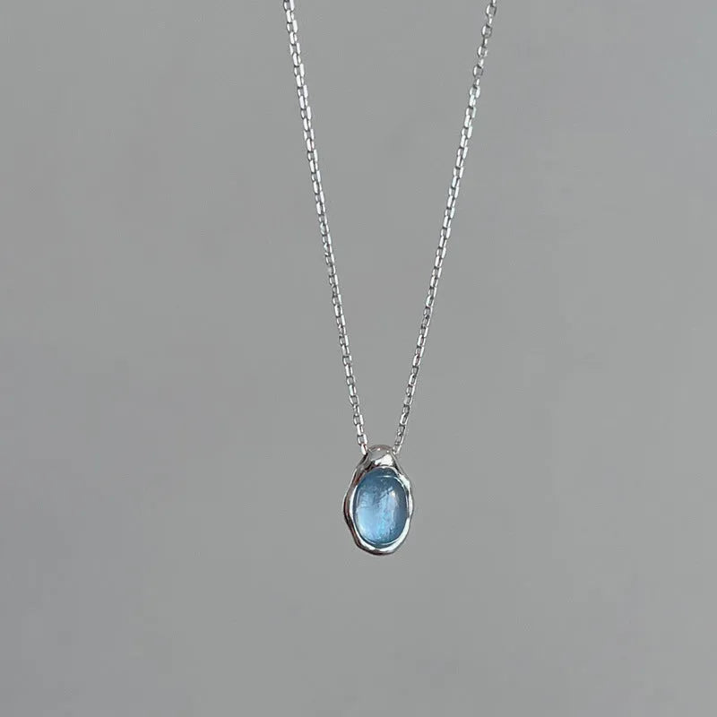 Navy blue water drop pendant necklace with platinum-coloured copper chain on display