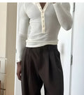 Men's cream-coloured ribbed long-sleeve henley top with a buttoned placket on a neutral background.
