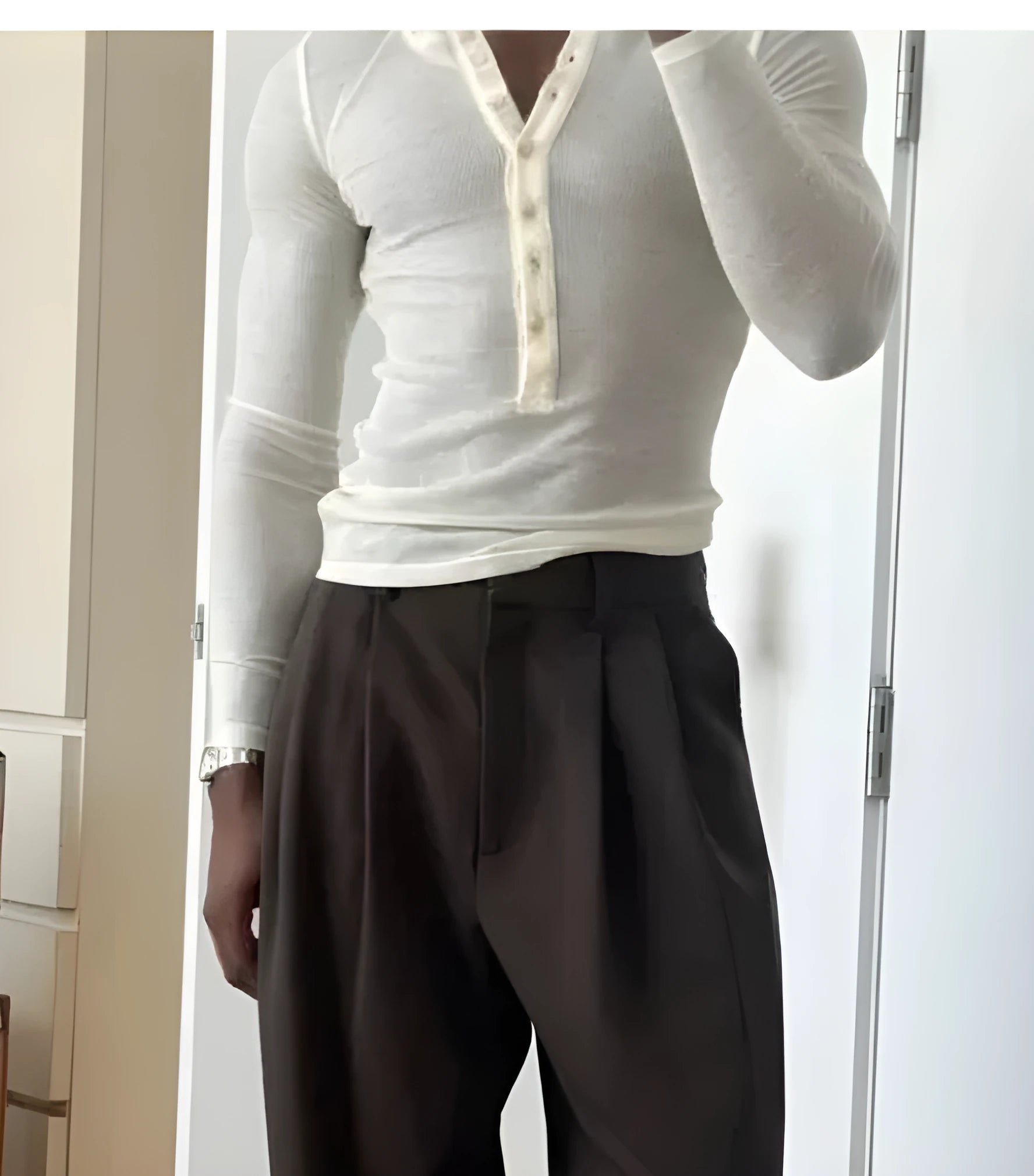 Men's cream-coloured ribbed long-sleeve henley top with a buttoned placket on a neutral background.